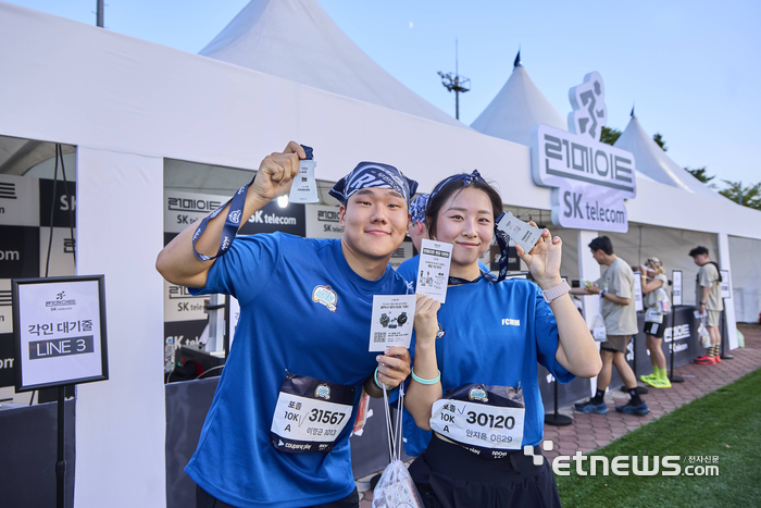 '런메이트 부스'에서 완주 기록 각인 서비스를 받은 러너 고객이 기념촬영했다.