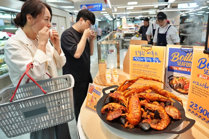 서울시 송파구에 위치한 롯데마트 제타플렉스 잠실점 '파일럿 키친'에서 '보일링 씨푸드'를 시식하고 있는 모습. 〈자료 롯데마트〉