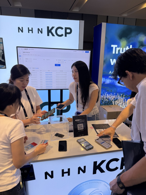 9월 30일 서울 워커힐 호텔앤리조트에서 열린 '코리아 블록체인 위크 2026'의 NHN KCP 부스에서 참관객이 원화 스테이블코인 결제 시연을 체험하고 있다
