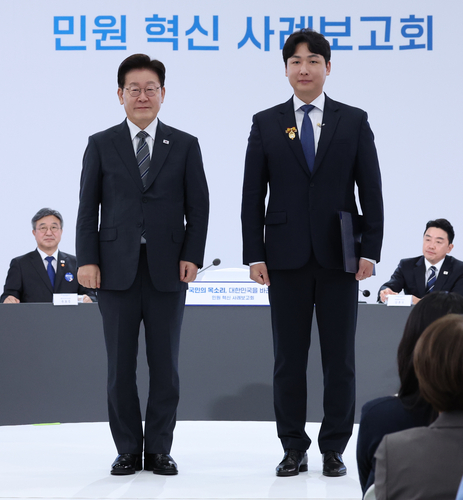 이재명 대통령이 2일 세종특별자치시에서 열린 민원혁신 사례보고회에서 민원해결, 제도혁신 우수 공무원으로 선정된 이상우 중소벤처기업부 전산사무관에게 대통령 표창을 수여한 뒤 기념촬영을 하고 있다.(사진=연합뉴스)
