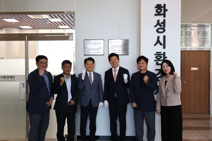 중소벤처기업인증원 엄진엽 원장(가운데 왼쪽), 화성시환경재단 정승호 대표이사(가운데 오른쪽)가 ISO 14001(환경)·45001(안전보건)·37001(부패방지) 및 HRMS(인권경영) 인증 수여식에서 인증 현판 부착 후 양 기관 주요 관계자들과 함께 기념촬영을 하고 있