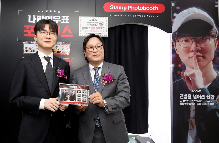 박인환 우정사업본부장(왼쪽 두번째)이 서울중앙우체국 우표박물관 '페이커 기획전시관' 개관식에서 페이커 이상혁 선수에게 기념우표를 전달하고 있다.