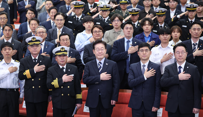 이재명 대통령이 13일 부산에서 열린 북극항로 시범운항 환영식에서 국기에 경례하고 있다. 연합뉴스