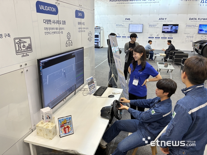 2026 The NEXT AI 어빌리티시스템즈 부스에서 한 관람객이 야드트랙터 주행 시뮬레이션을 체험하고 있다.