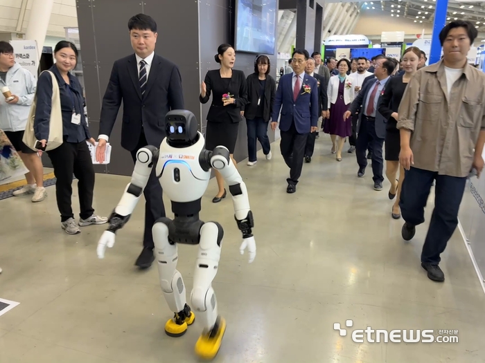 2026 The NEXT AI 개막식에 참석하는 주요 내빈들이 휴머노이드 로봇의 안내를 받아 입장하고 있다.