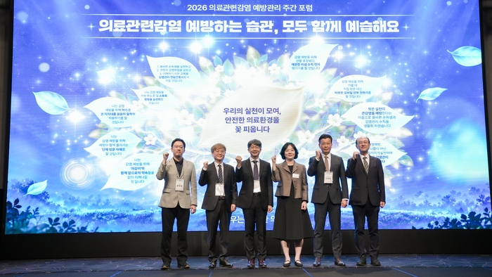 임승관 질병관리청장(왼쪽에서 세번째)과 주요 참석자들이 16일 서울 엘타워에서 열린 '2026년 의료관련감염 예방관리 주간 포럼'에서 감염예방 실천 의지를 다지는 희망트리 앞에서 기념촬영하고 있다.
