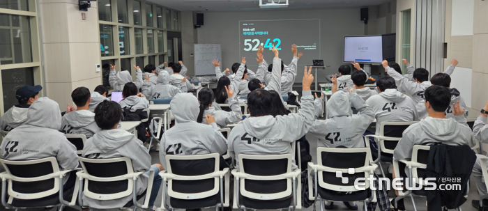 42경산 캠퍼스 개선 및 서비스 개발 공모전 '42.Zip' 킥오프 행사에서 교육생들이 손을 들어 호응하고 있다.  [출처:경산이노베이션아카데미 제공]