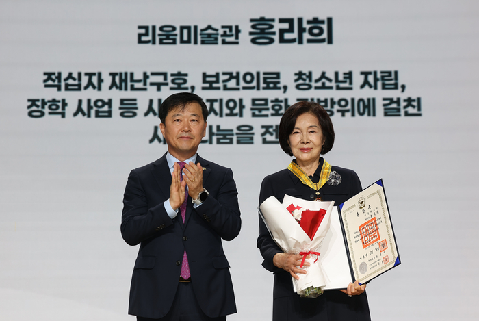홍라희 리움미술관 명예관장(오른쪽)이 26일 서울 중구 우리은행 본점에서 열린 대한적십자사 창립 121주년 기념식에서 이형훈 보건복지부 차관에게 국민훈장 동백장을 받은 뒤 기념촬영하고 있다.