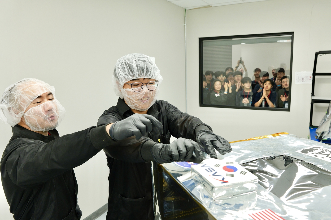 문재성 학생(대덕중학교 1학년, 오른쪽)이 김정균 보령 대표와 달 타임캡슐을 달 착륙선 IM-3에 부착하고 있다.