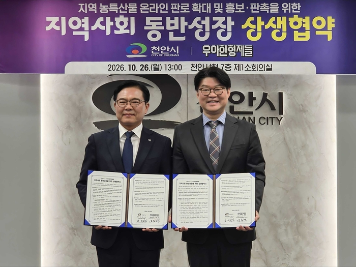 배달의민족을 운영하는 우아한형제들은 지난 26일 충남 천안시 천안시청에서 '지역사회 동반성장' 상생협약식을 개최했다. 김중현 우아한형제들 지속가능경영실장(오른쪽)과 김석필 천안시 부시장이 협약서를 들어보이고 있다. 〈자료 우아한형제들〉
