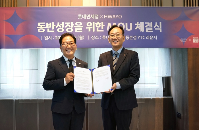지난 26일 김원식 롯데면세점 명동본점장(오른쪽)과 박정화 화요 영업본부장이 MOU 체결 후 기념 촬영을 하고 있다.