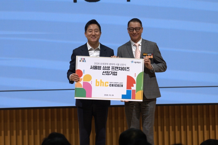 지난 29일 서울 중구 서울시청에서 열린 '2026 상생경제 생태계 서울' 선포식에서 다이닝브랜즈그룹 송호섭 대표(오른쪽)가 오세훈 서울시장과 우수 가맹본부 선정 기념 촬영을 하고 있다. 〈자료 다이닝브랜즈그룹〉