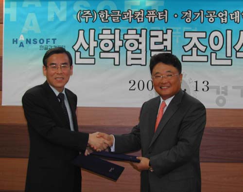 정태신 경기공업대학 학장(왼쪽)과 백종진 한컴 사장이 ’IT활용교육에 관한 산학협력 MOU’를 교환하고 악수하고 있다.