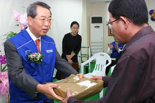 삼성코닝 송용로 사장(왼쪽)이 노숙인 인문학도에게 선물을 전달하고 있다