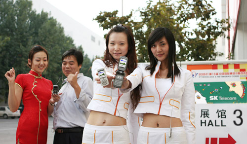 ‘PT/와이어리스&네트워크 커뮤니케이션 차이나 2005’ 전시장 앞에서 중국 모델들이 출품작들을 시연해 보이고 있다.