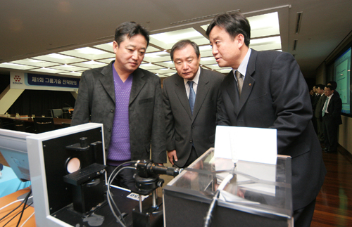 코오롱그룹 이웅열 회장(왼쪽)이 15일 열린 우수연구 사례 발표회에서 코오롱 한광희 사장(가운데)과 송석정 중앙기술원장(오른쪽)으로부터 나노섬유를 뽑아내기 위한 ‘전기방사 장치’에 대한 설명을 듣고 있다.