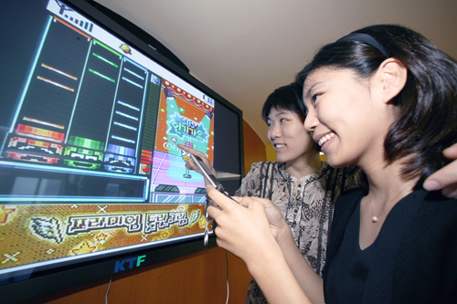 KTF 서울 강남 멤버스 플라자에서 고객이 TV화면을 통해 휴대폰 게임을 즐기고 있다.