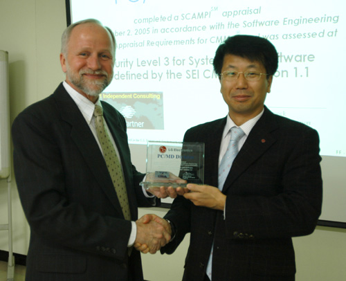 LG전자 평택디지털파크 미디어연구소에서 열린 ‘CMMI 레벨3 인증 수여식’에서 노먼 해먹 SEI 심사원이 LG전자 PC개발실장 차균오 연구위원(오른쪽)에게 인증서를 전달하고 있다.