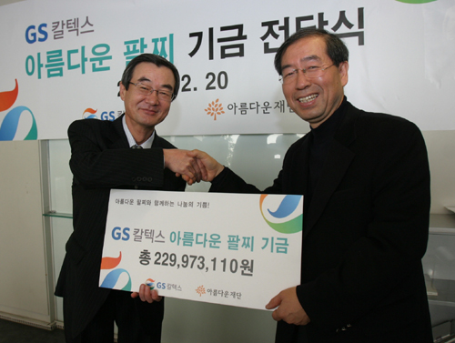 김건중 GS칼텍스 사장(왼쪽)이 아름다운재단 박원순 상임이사에게 전국 주유고객 10만 명이 모금한 ‘아름다운 자선팔찌 기금(1억2000만원상당)’과 ‘기업매칭그랜트 기금(1억원)’을 전달하고 악수를 하고 있다.