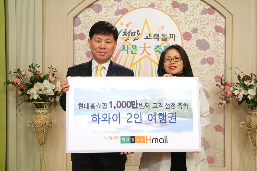 하병호 현대홈쇼핑 전무(왼쪽)가 15일 서울 용산 스튜디오에서 1000만번째 이용고객인 박향선씨에게 하와이 여행상품권을 증정하고 기념촬영하고 있다.