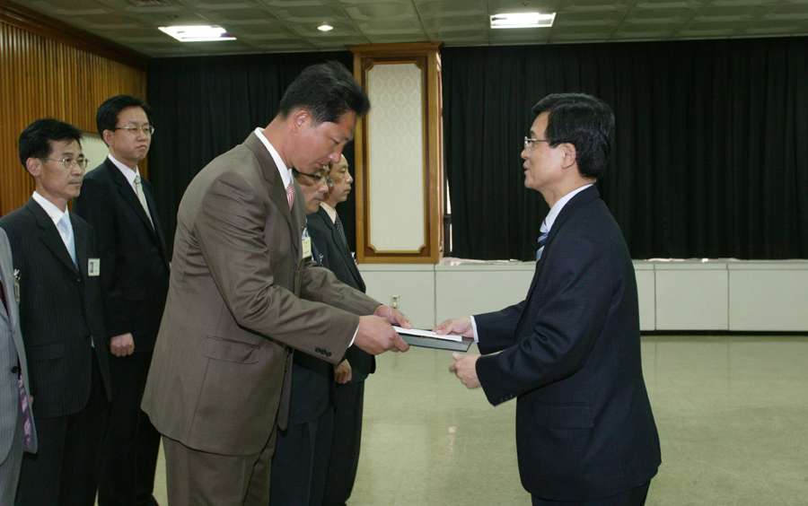 황중연 우정사업본부장이 박동기 집배원에게 표창장을 수여하고 있다.