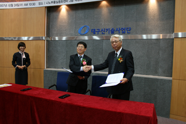 유봉 나노부품실용화 센터장(왼쪽)과 무타이사오 히타치테크놀로지 본부장이 협력조인식을 가진뒤 악수하고있다.