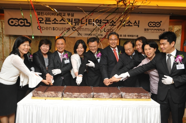  　22일 소공동 롯데호텔에서 열린 ‘오픈소스 커뮤니티 연구소’ 개소식에 참석한 관계자들이 떡을 커팅하며 축하하고 있다. 왼쪽부터 추애주 성주그룹 대표, 박두례 부천시청 상임이사, 장익수 열린사이버대 이사, 변진 열린사이버대 이사장, 박태웅 열린사이버대 총장 직무대행, 박진 국회의원, 윤해중 전 인도네시아 이사, 김영종 오픈소스커뮤니티 연구소장, 조윤희 한양대 교수, 박영민 열린사이버대 이사.