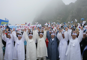  　14일 오전 경북도가 독도에서 개최한 ‘일본 교과서 독도 도발 규탄대회’에 참석한 김관용 도지사(앞줄 가운데 안경 쓴 사람) 등이 손에 태극기를 들고 만세를 부르며 독도 수호의지를 다지고 있다.