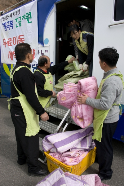 태백시 장성동에서 자원봉사단 함께 무료세탁차량에서 세탁물을 옮기고 있다. 