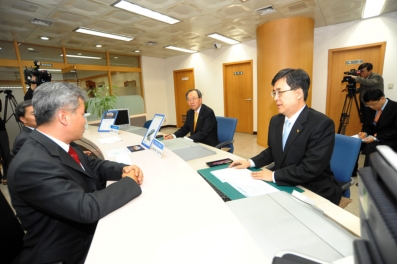 진동수 금융위원장(오른쪽)이 부산은행 부전동지점에서 일일 지점장으로 근무하며 고객과 상담을 하고 있다. 