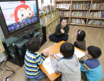 서울 광진구 새날아동센터(KT공부방)에서 어린이들이 선생님과 IPTV로 만화를 즐기고 있다.