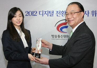 김연아 선수(왼쪽)가 최시중 방통위원장으로부터 위촉패를 받고 있다.