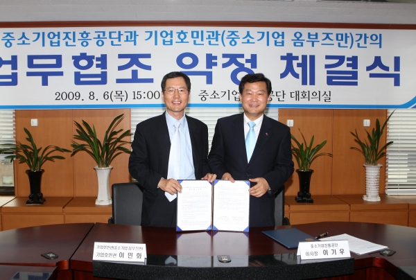 이민화 중소기업호민관(왼쪽)과 이기우 중진공 이사장이 업무협약 체결 후 환하게 웃고 있다.