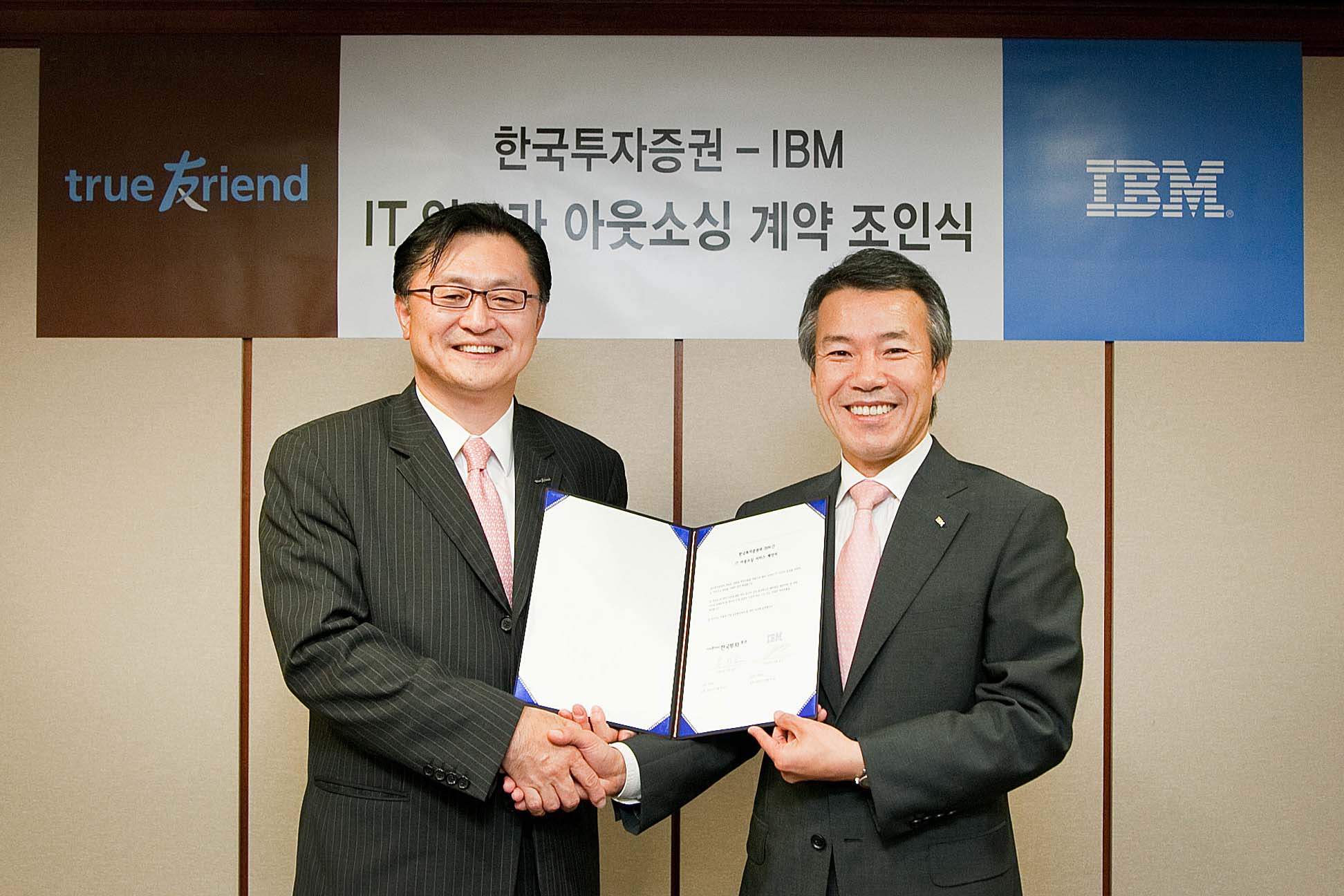 유상호 한국투자증권 사장(왼쪽)과 이휘성 한국IBM 사장이 10년간 IT아웃소싱 계약을 체결하고 악수를 나누고 있다.