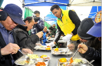  아흐메드 에이 수베이 S-OIL CEO가 쪽방촌 거주민에게 직접 떡국을 나눠주고 있다. 