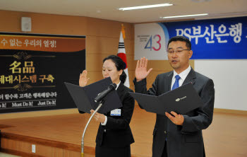 부산은행 본점 강당에서 열린 차세대시스템사업 착수 보고회에서 양민훈 부산은행 차세대개발부 과장(오른쪽)과 SK C&C 임소영 차장이 차세대개발 결의문을 낭독하고 있다.