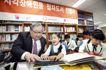 한화그룹 김연배 부회장이 수유동 한빛맹학교에서 어린이들에게 점자도서 등 시각장애인용 특수도서를 전달하고, 어린이들과 도서관에서 함께 책을  읽고 있다.
 
  
 