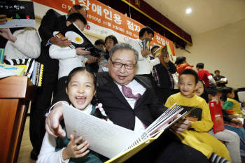 한화그룹 김연배 부회장이 수유동 한빛맹학교에서 어린이들에게 점자도서 등 시각장애인용 특수도서를 전달하고, 어린이들과 도서관에서 함께 책을  읽고 있다.
 
  
 