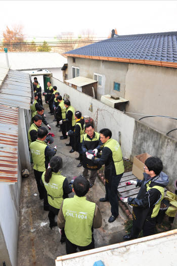 한국석유관리원 이천호 이사장(오른쪽 세번째)을 비롯한 임직원들이 수원시에 거주하는 저소득층 및 불우한 가정 3가구에 사랑의 연탄을 릴레이로 배달하고 있다.
 