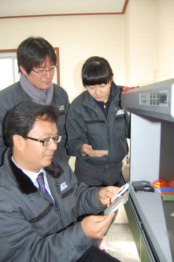 크레진의 김경웅 대표(앉은 사람)가 연구원들과 자신들이 개발한 소재를 검사하고 있다.