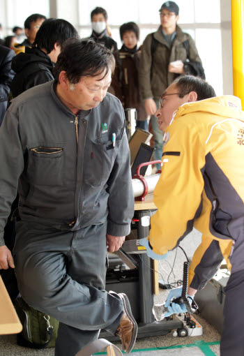 일본 후쿠시마에서 출발한 항공기에 탑승했던 한 승객이 17일 영종도 인천국제공항을 통해 입국하며 방사능 오염 감시기에 감지, 한국원자력 기술원 관계자에게 정밀검사를 받고 있다.
 연합뉴스
 