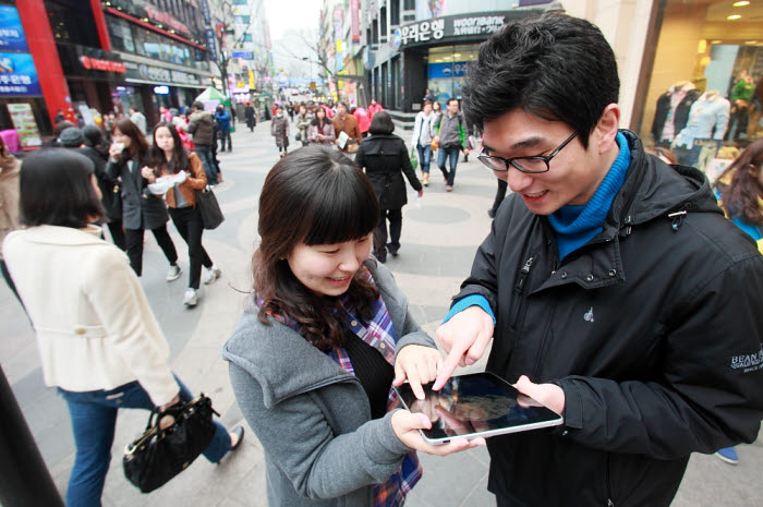 KT 고객들이 `CCTV 와이파이`가 설치된 서울 명동 거리에서 무선인터넷 서비스를 이용하고 있다.