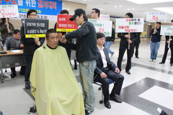 최승재 한국인터넷PC방협동조합 이사장(오른쪽)이 19일 PC방 전면 금연구역 설정에 항의하며 삭발을 하고 있다.