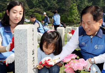 서진원 신한은행 행장(오른쪽)과 직원 및 가족이 28일 국립현충원에서 비석 음각 비문을 먹물로 다시 칠하는 봉사활동을 펼치고 있다. 