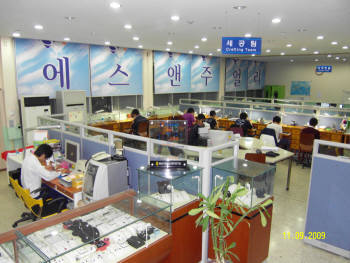 충남기계공업고등학교의 학교기업 에스앤주얼리의 사무실 전경. 앞쪽에 은세공품을 담아 놓은 장식장과 중간 부분에 학생들의 작업하는 모습이 보인다.