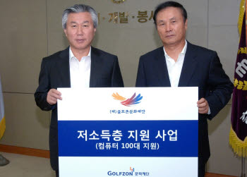 김영찬 골프존문화재단 이사장(오른쪽)이 송용호 충남대 총장에게 컴퓨터 100대를 기증한 후 기증서를 펼쳐보이고 있다.