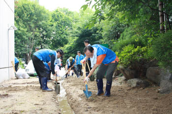 한국환경공단 직원들로 구성된 에코봉사단원들이 토사를 제거하며 배수로를 내고 있다.