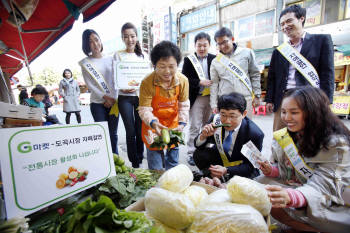 전통시장 활성화를 위해 도곡시장과 자매결연을 맺은 G마켓 임직원들이 온누리상품권을 이용해 전통시장 구매체험 행사를 진행하고 있다. 
 