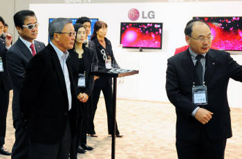 구본무 LG 회장이 지난 6일 일산 킨텍스에서 열린 `LG전자 한국마케팅본부 정책설명회`를 방문, 새해 첫 현장경영을 펼쳤다. 구 회장이 조택일 LG전자 TV상품기획그룹 상무로부터 올해 출시 예정인 LG전자 55인치 3D OLED TV에 대해 설명을 듣고 있다. 왼쪽부터 최상규 LG전자 한국마케팅본부장 부사장, 구본무 회장, 조택일 LG전자 TV상품기획그룹 상무.
 