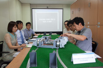 한국철도기술연구원 저심도경전철연구단 연구원들이 모형 시험을 보며 문제점을 검토하고 있다.